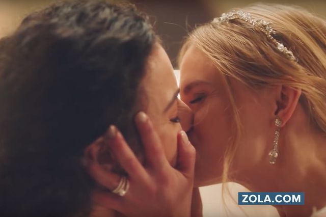 This is a photo of two women kissing on their wedding day, from a Zola ad.